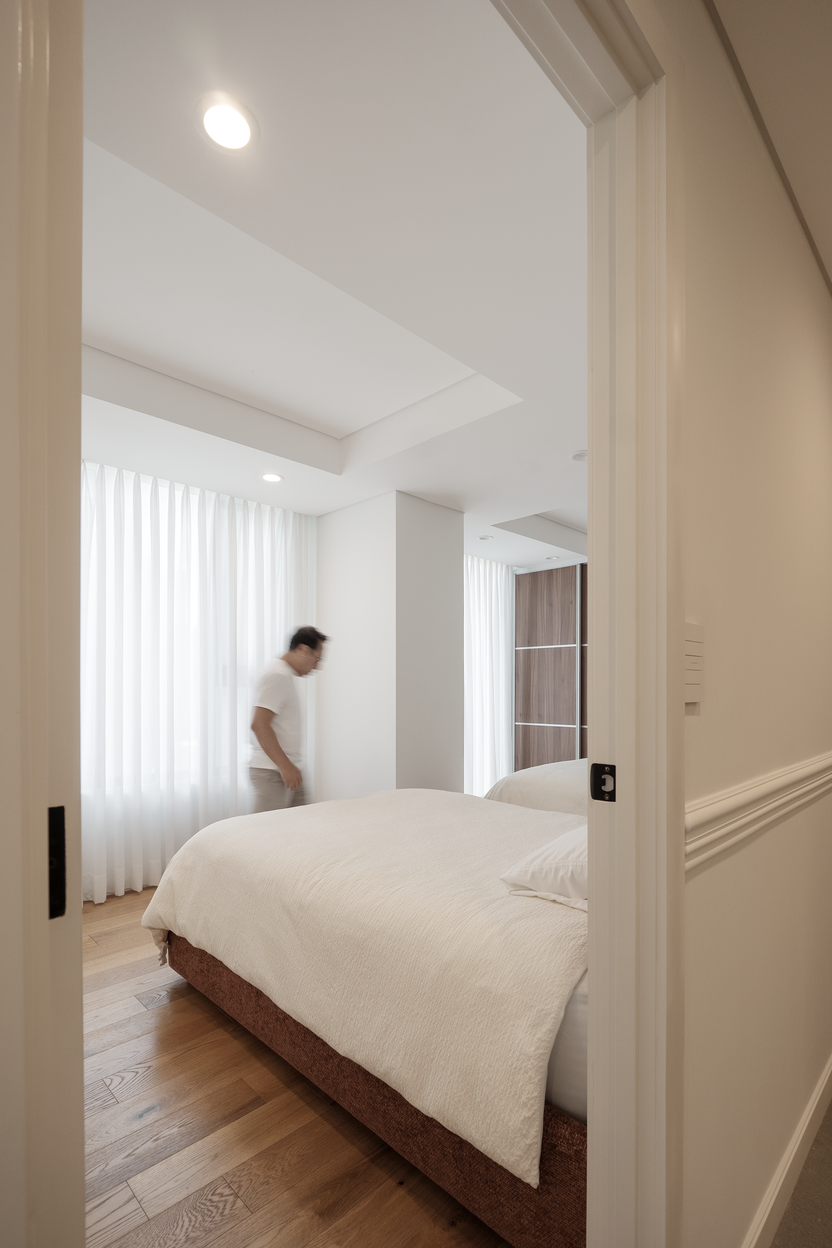 Cama tapizada e iluminación de lectura en dormitorio principal